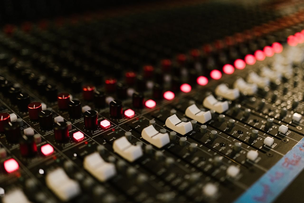 Crafting Captivating Headlines: Your awesome post title goes here Close-up of a sound mixing console with illuminated control knobs in a music studio.